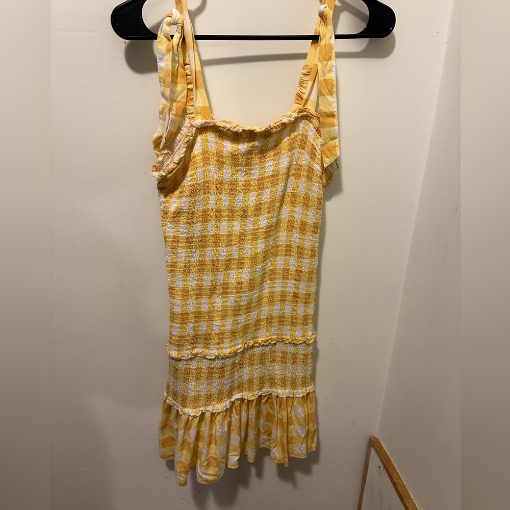Yellow plaid drop-waist dress with smocking throughout. Tie bows on shoulders.